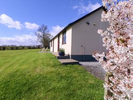 A house with a pathway and flowering plant at Sunny Cottage in Brecon