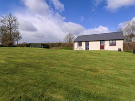 A house with a table and chairs on a lawn at Sunny Cottage in Brecon