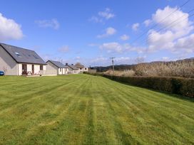 An outdoor view of houses and lawn at Sunny Cottage in Brecon
