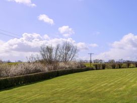 A lawn with trees and bushes at Sunny Cottage in Brecon