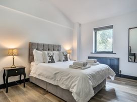 A bedroom with a bed, nightstand, and lamp at The Annex in Wimborne Minster