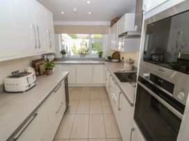 A kitchen with cabinets, sink, and appliances at Trem Ynys in Mynytho near Abersoch