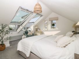 A bedroom with a bed and windows at Trem Ynys in Mynytho near Abersoch