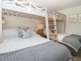 A bedroom with a bunk bed and a double bed at Trem Ynys near Abersoch