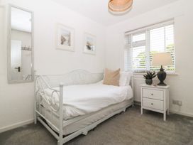 A bedroom with a bed and nightstand at Trem Ynys in Mynytho near Abersoch