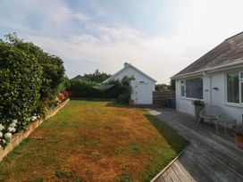 A garden with wooden decking and flower beds at Trem Ynys near Abersoch