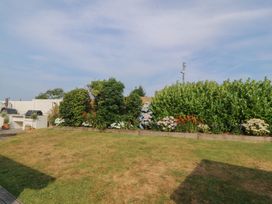 A garden with flowers and a barbecue at Trem Ynys near Abersoch