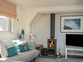 A living room with a wood stove and television at The Lookout in Polzeath