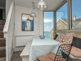 A dining room with a table and cushions at The Lookout in Polzeath