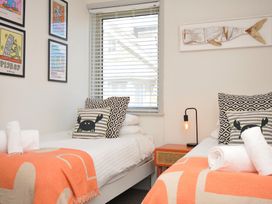 A bedroom with two beds and artwork on the walls at The Lookout Polzeath