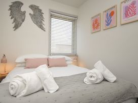 A bedroom with a bed and wall art at The Lookout in Polzeath