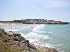 A beach with people and waves at The Lookout in Polzeath