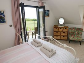 A bedroom with a bed, dresser, and mirror at North Studdock Cottage near Pembroke
