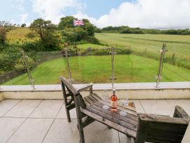 A patio with wine glasses and a garden view at North Studdock Cottage Angle near Pembroke