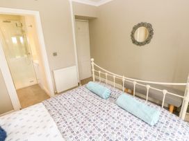 A bedroom with a bed and towels at North Studdock Cottage in Angle near Pembroke
