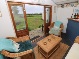 A snug with woven chairs and a coffee table at North Studdock Cottage Angle near Pembroke