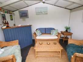 A snug with wicker furniture and a bar counter at North Studdock Cottage Angle near Pembroke