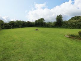 A garden with grass and a fire pit at North Studdock Cottage, Angle near Pembroke