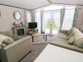 A living room with sofa and television at Oyster Lodge in Little Haven