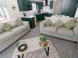 A living room with sofas and a coffee table at Oyster Lodge in Little Haven