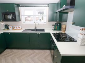 A kitchen with a sink and stove at Oyster Lodge in Little Haven