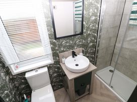 A bathroom with a sink and shower at Oyster Lodge in Little Haven