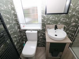 A bathroom with a toilet and sink at Oyster Lodge in Little Haven