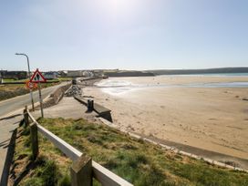 A beach scene with a road and houses at Ocean House in Broad Haven