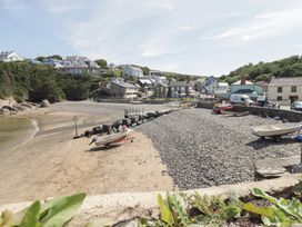 A beach with boats and rocks at Driftwood Lodge Hasguard Cross near Broad Haven