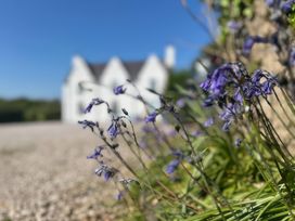 Flowers in the foreground and a house in the background at Cae Du, Dwyran near Niwbwrch (Newborough)