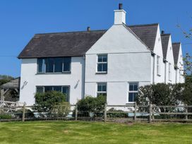 An exterior view of a house with windows and a garden at Cae Du in Dwyran near Niwbwrch (Newborough)