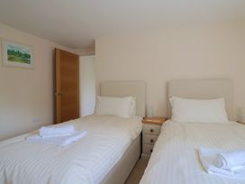 A bedroom with two single beds with white linens and towels on them at Fig Tree House in Axminster