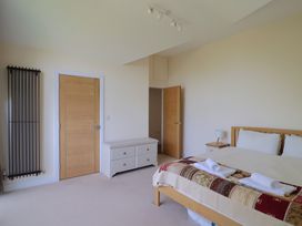 A bedroom with a bed bed side table radiator two doors and a chest of drawers at Fig Tree House in Axminster