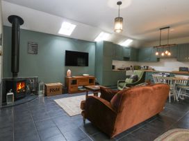 A living room with a wood stove and sofa at The Old Tannery in Beaumaris