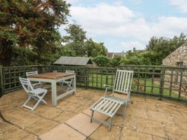 A patio area with a table, chairs, and a sun lounger at The Old Tannery in Beaumaris