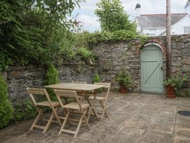 A garden with a wooden table and chairs at The Old Tannery Beaumaris