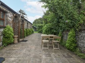 A garden with a table and chairs beside a stone wall at The Old Tannery Beaumaris