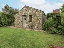 A stone building with a patio and outdoor furniture at The Old Tannery in Beaumaris