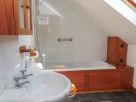 A bathroom with a bathtub and sink at Beech Tree Cottage Waunfawr