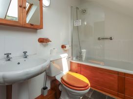 A bathroom with a sink toilet and a bathtub at Beech Tree Cottage in Waunfawr