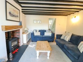A living room with sofas and a fireplace at Craig Mawr in Benllech