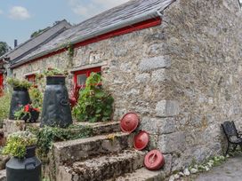 An outdoor area with stone steps and black and red pots at The Dairy in Ardfinnan, County Tipperary