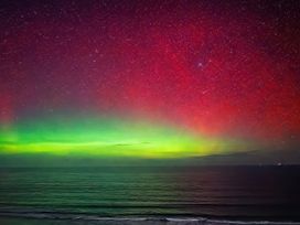 A night sky with aurora borealis over the ocean at Surf and Sand in Carbis Bay