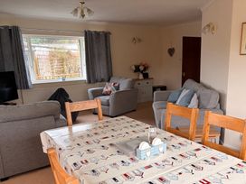 A living room with a table and chairs at 14 Cae Pin in Abersoch