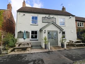 The exterior of The Black Horse Inn with picnic tables and potted plants at Duck Lodge in Bedale