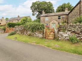 A stone house with a garden and a wooden gate at White House in Shap