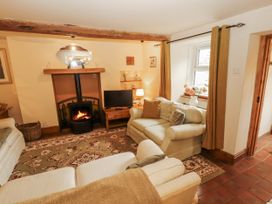 A living room with a fireplace and television at White House in Shap