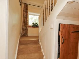 A hallway with stairs leading up and a window at White House in Shap