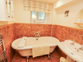 A bathroom with a bathtub and washbasin at the White House in Shap