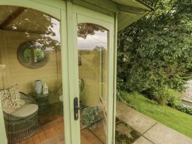 A garden room with chairs and a table at White House in Shap